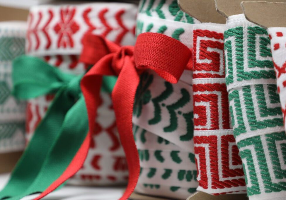 Christmas ribbons in boxes with red and green ribbons.